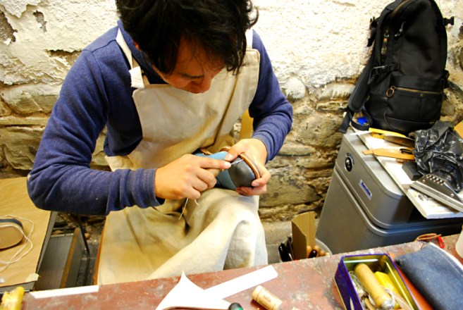 Yusuke preparing to hand stitch a sole.